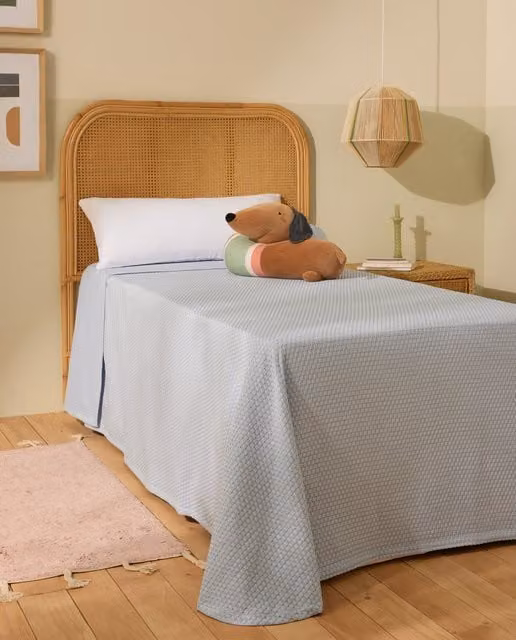 Colcha infantil New Claire Mini Home de El Corte Inglés con diseño geométrico en azul y tejido jacquard acolchado