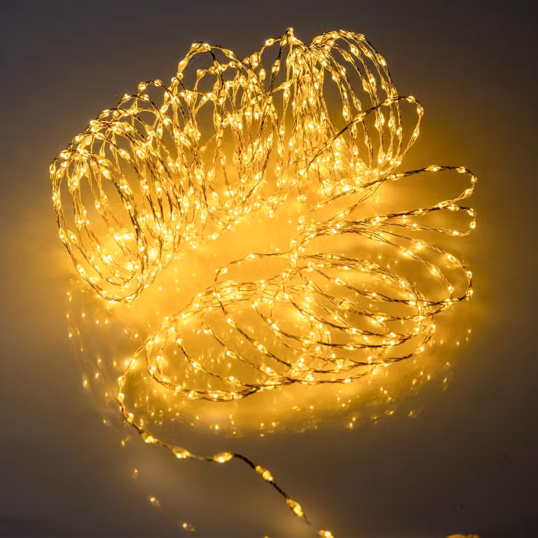 Cadena de luces LED Spetebo de 567 luces en color blanco cálido con cable plateado de 9 metros, temporizador ajustable y funciones para Navidad, apta para interiores y exteriores