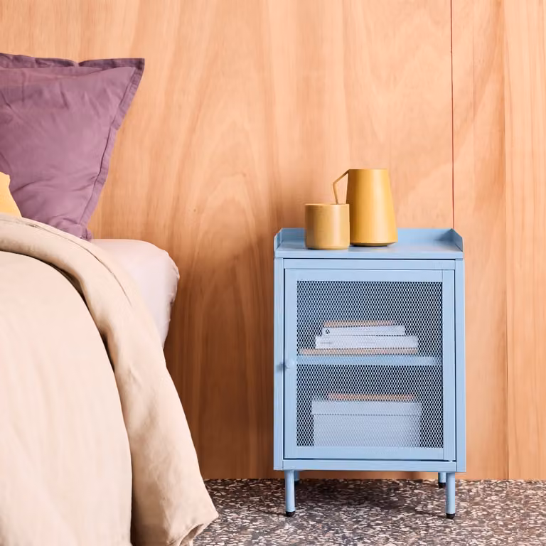 Mesita de noche de estilo industrial Sweeek en metal azul claro con una puerta de rejilla