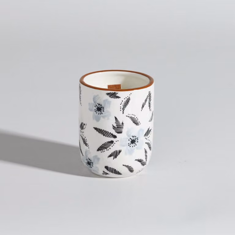 Vela de cera con aroma floral y frutal en recipiente de cerámica redondo de Maisons du Monde, colores beige, azul, negro y blanco