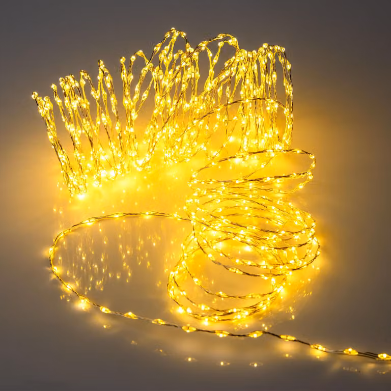Cadena de luces LED Spetebo de 756 luces en color blanco cálido con cable plateado de 12 metros, con temporizador y funciones ajustables, apta para interiores y exteriores con protección IP44
